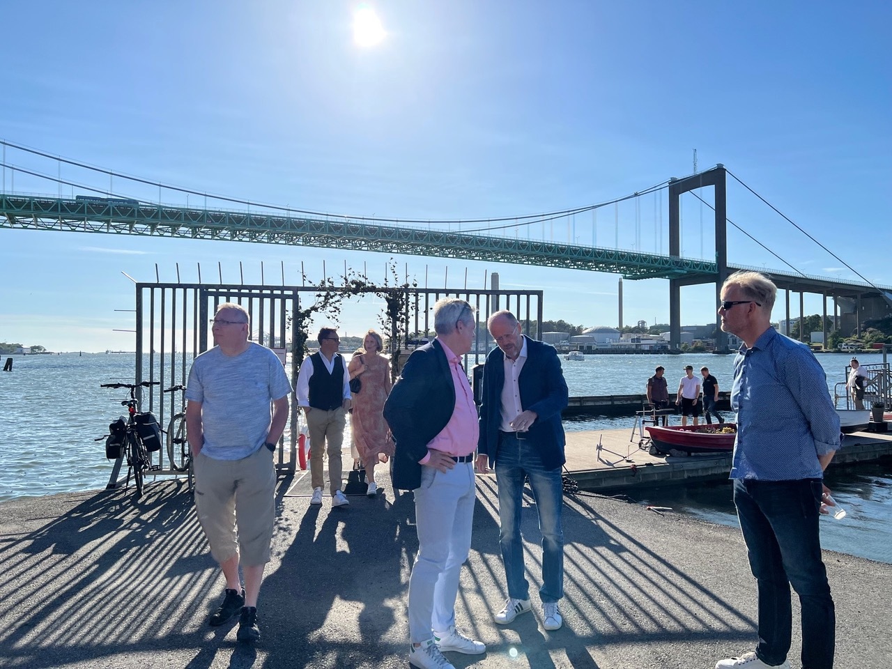 Outdoors. People mingling with the Älvsborg bridge of Gothenburg, Sweden in the background.